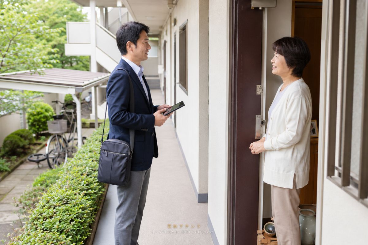 小金井市の住宅へ出張買取スタッフが訪問するイメージ 小金井市の低層集合住宅の玄関外で出張買取スタッフが住人にあいさつするイメージ